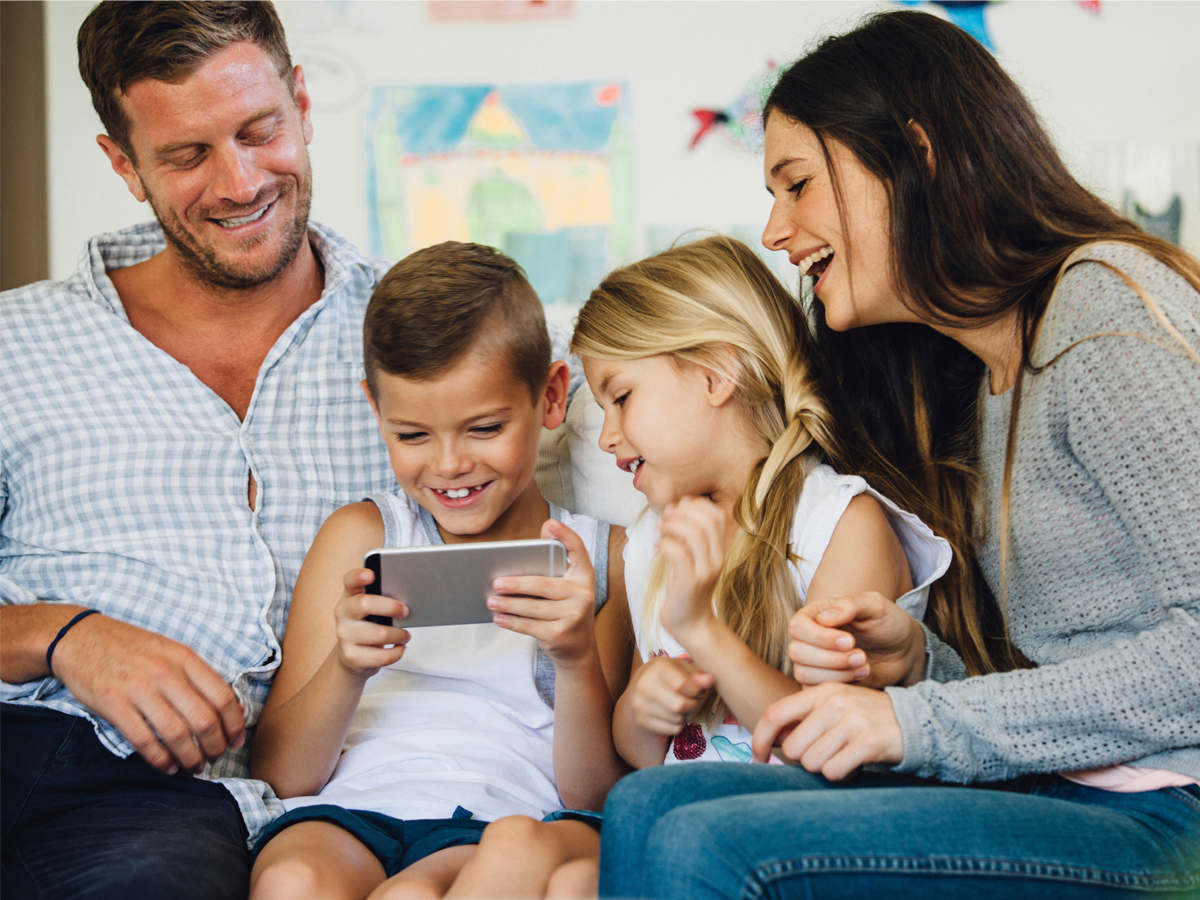 Happy family smiling and looking at a smart phone