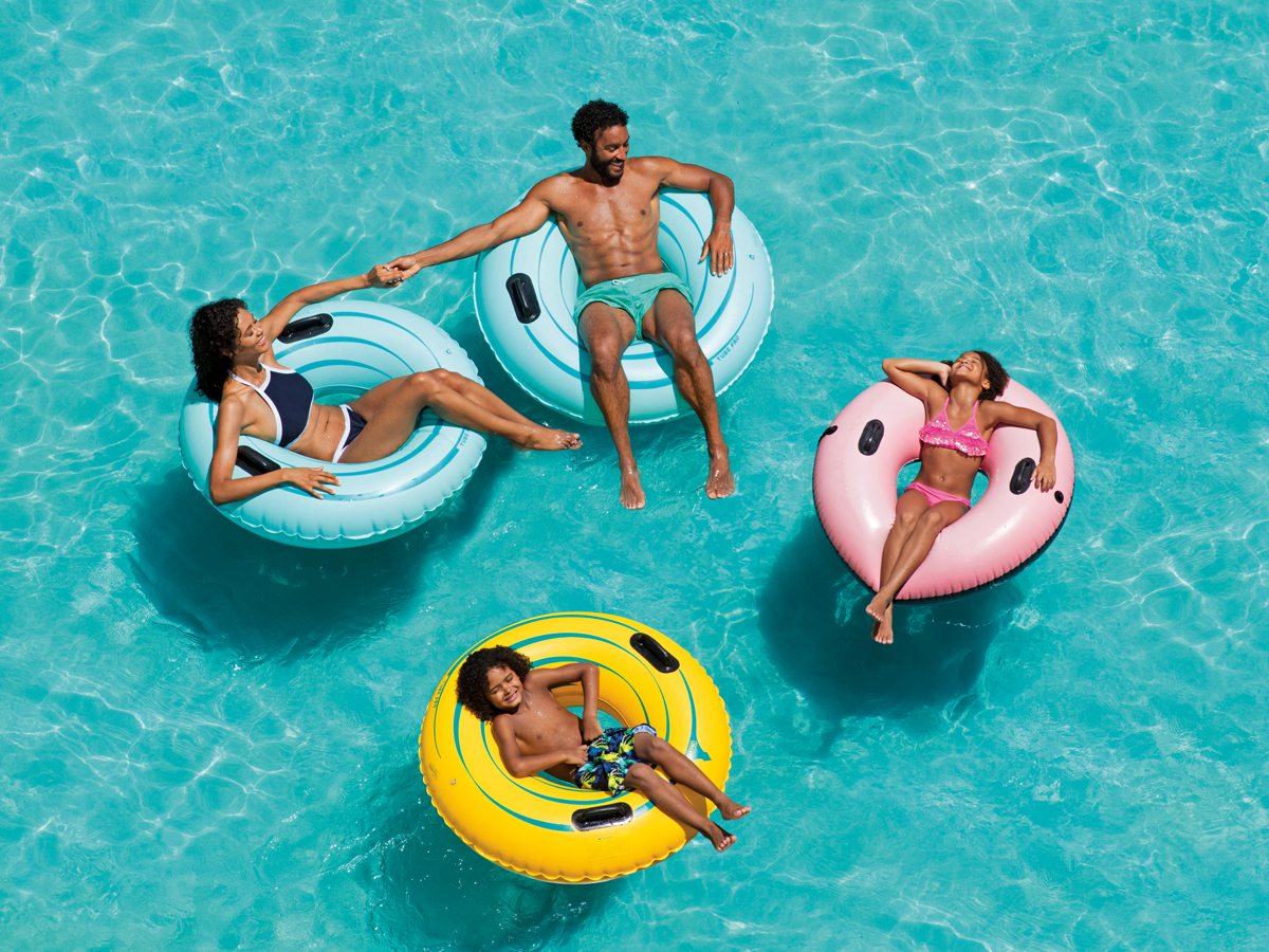 Family of four on pool floats in the middle of a pool