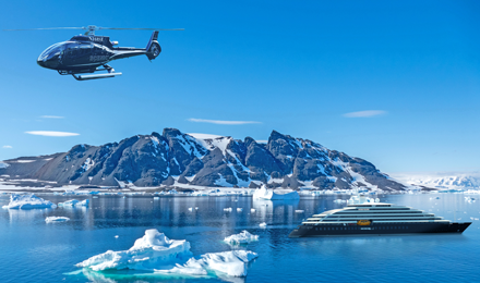 Scenic Eclipse ship sailing in a cold destination with the exclusive helicopter flying overhead