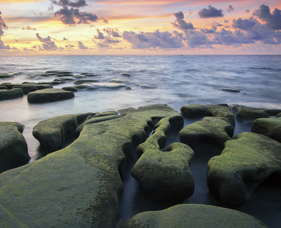 Our story: sunset, ocean formed large stones