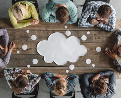 Join our team: a team of young professionals around a table with a thought bubble graphic on top of the table