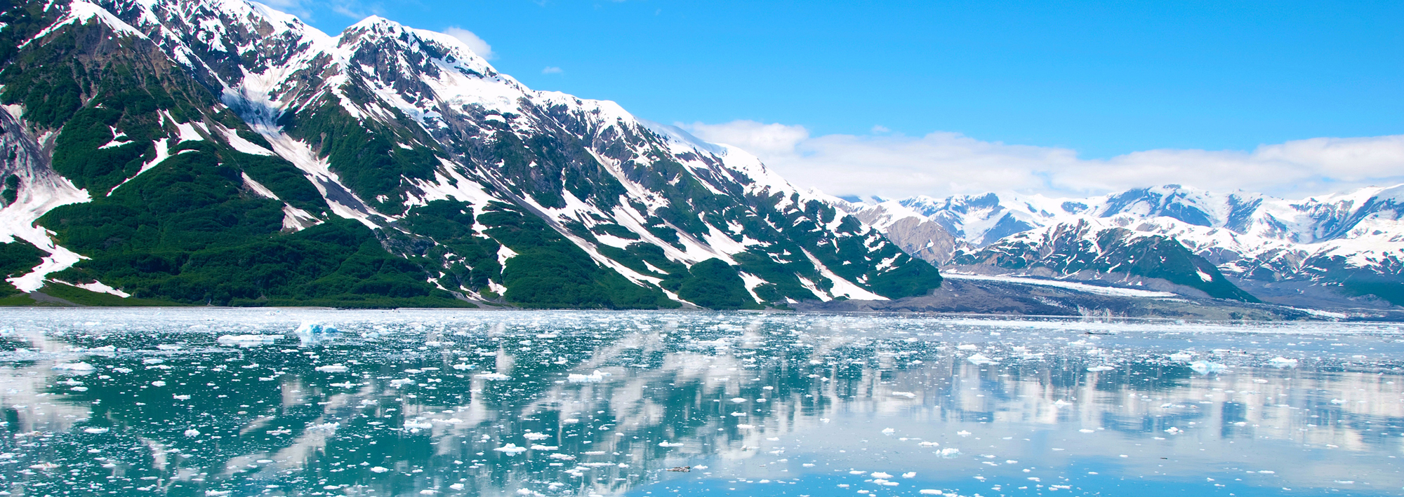 Icy water, snow covered mountains in Alaska