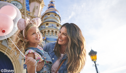 Mother and daughter in front of Cinderella's castle with pink Mickey balloon