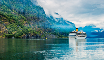Cruise ship sailing in a rocky mountain fjord
