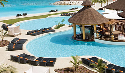 Beautiful clear blue pool with lounge chairs and a swim-up bar