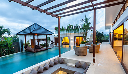 Luxury hotel room with infinity pool, lounge area and lush landscaping