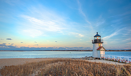 Lighthouse at sunset with water in the background