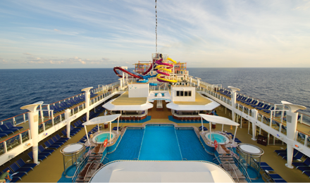Norwegian Cruise Line deck with pool and slides sailing in blue ocean water