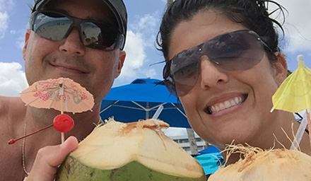 Cute couple celebrating with a tropical drink inside of a coconut